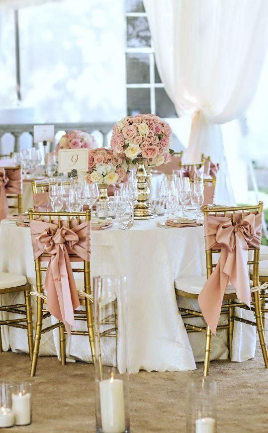 the table is set with pink flowers and gold chairs for an elegant wedding reception in vegas, nv