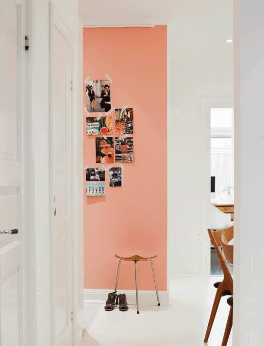 an open door leading to a dining room with pink walls and pictures on the wall