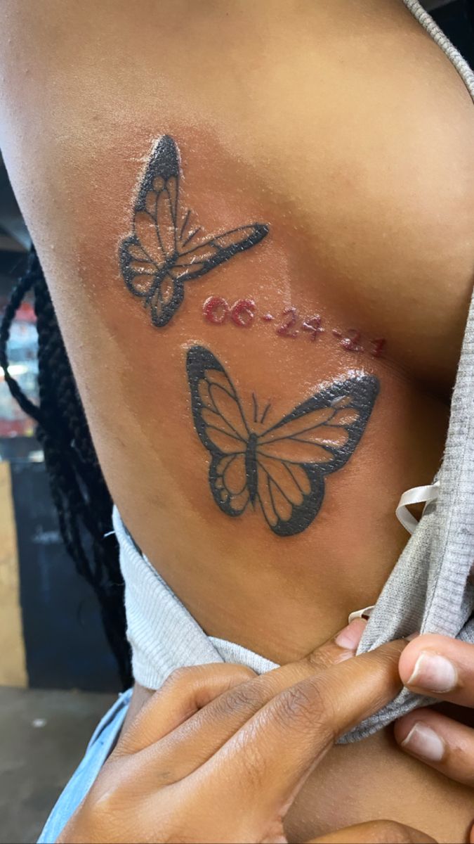 a woman with tattoos on her back and butterflies painted on the side of her body