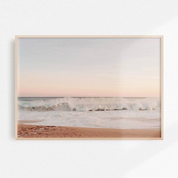 an ocean scene with waves crashing on the shore and pink sky in the back ground