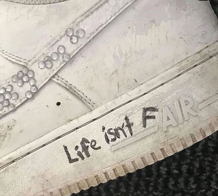 an old pair of shoes with the words life isn't fair written on them