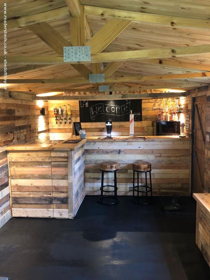 a bar made out of pallet wood with stools