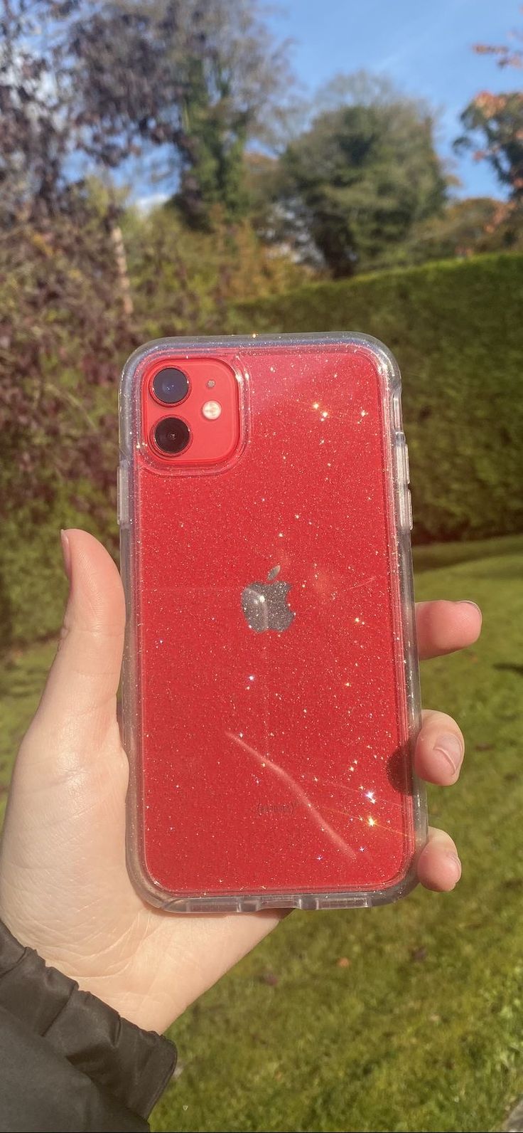 a person holding up a red iphone case in their hand with the back cover partially covered