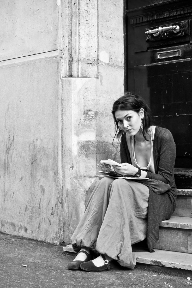 a woman sitting on steps reading a book