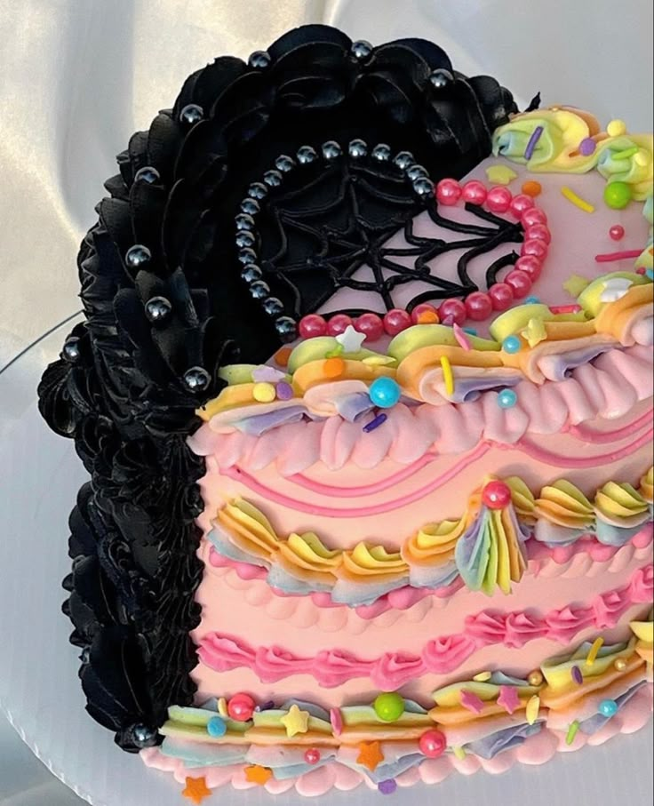 there is a large cake decorated with black and pink icing