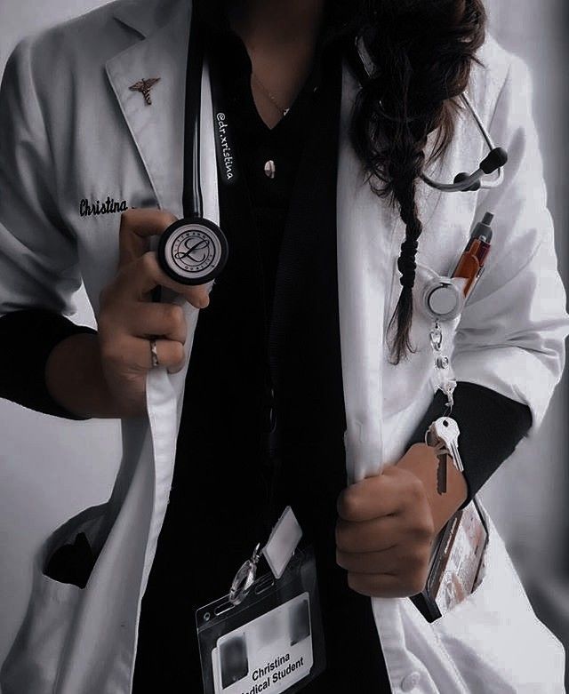 a woman wearing a white lab coat and holding a badge