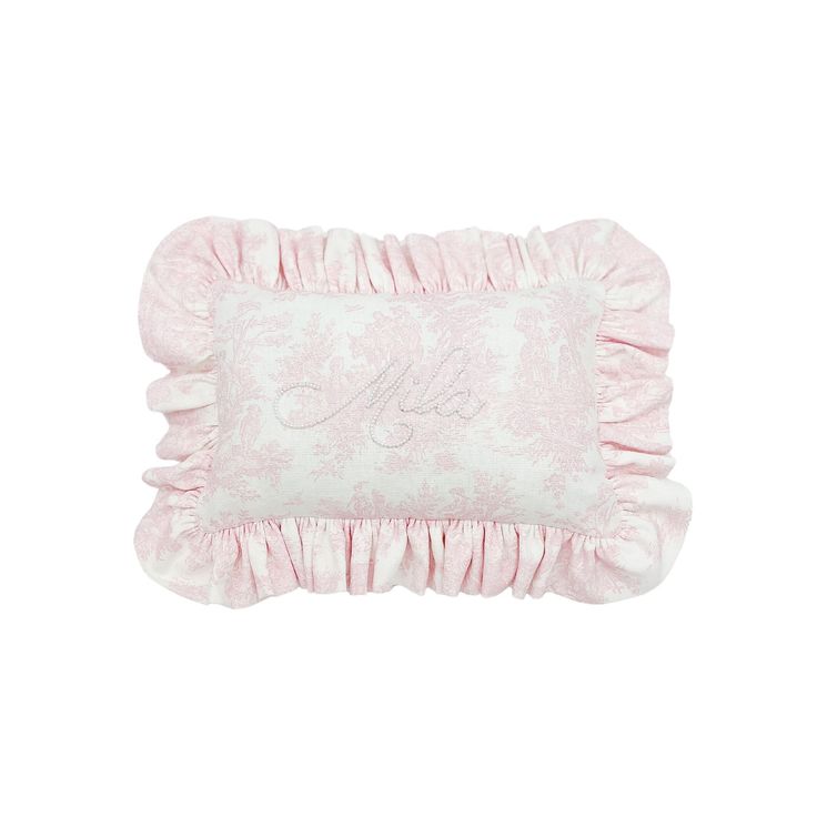 a pink pillow with ruffled edges and embroidered monogrammed letters on the front