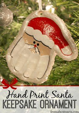 a handprint santa ornament hanging from a christmas tree with text overlay