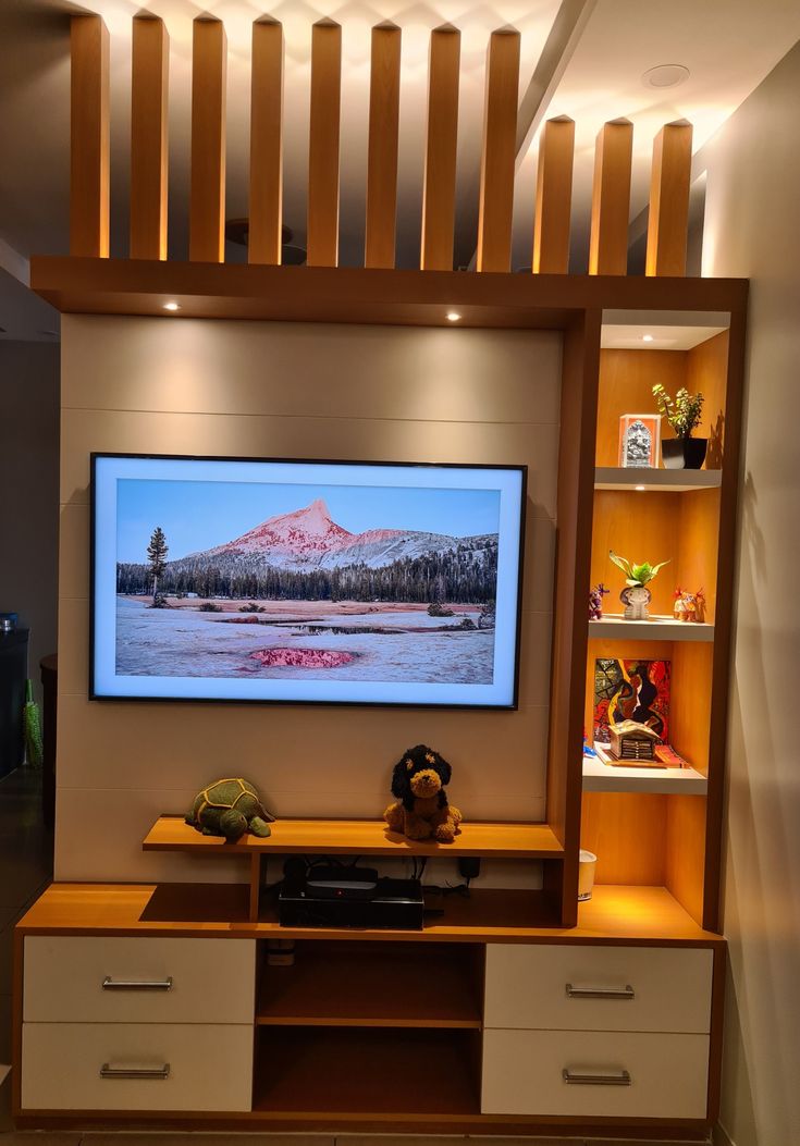 an entertainment center with a flat screen tv mounted on it's wall and wooden shelves