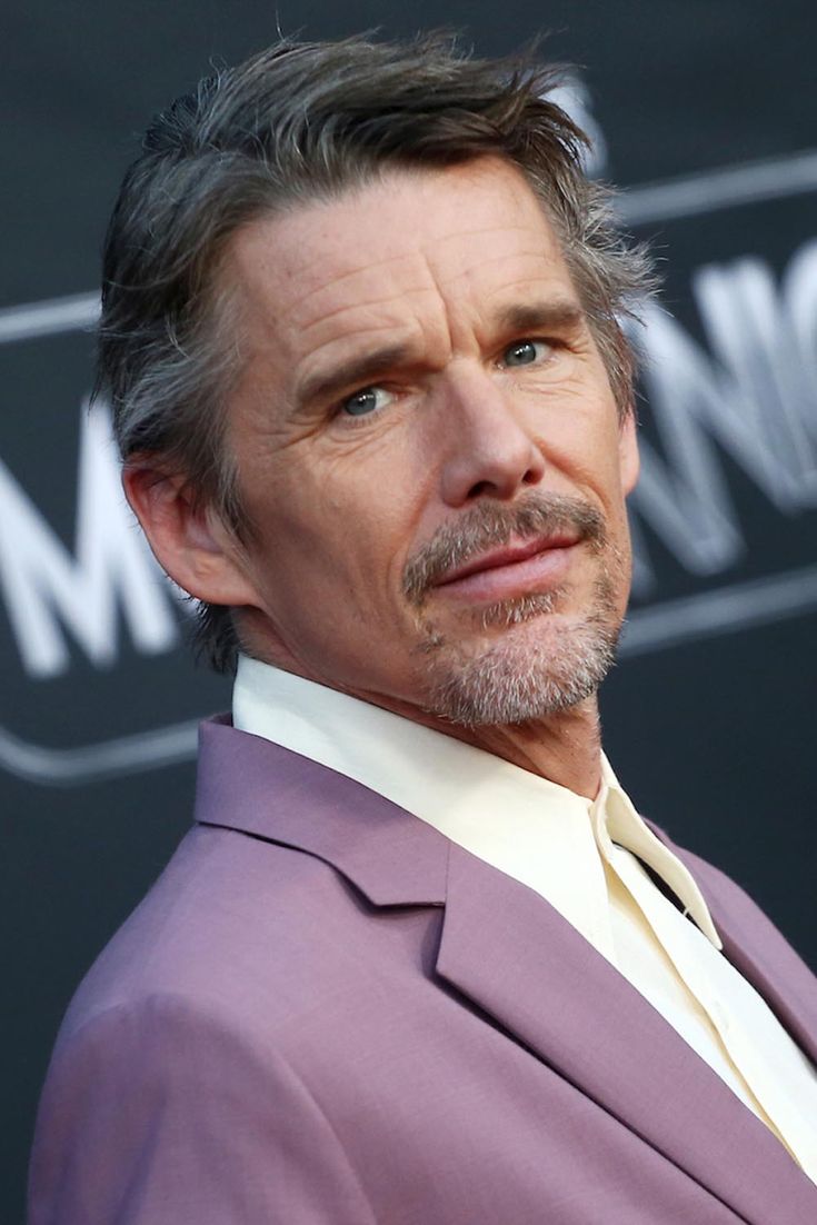 a close up of a person wearing a purple suit and tie with his eyes closed