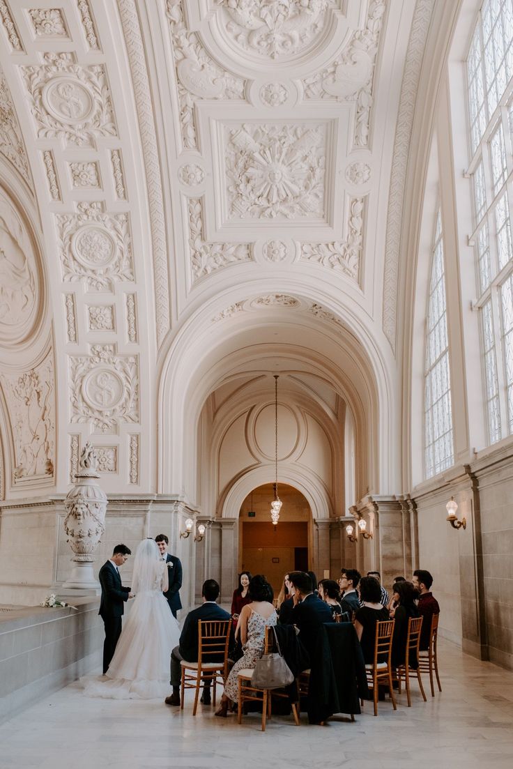 a bride and groom standing at the end of their wedding ceremony in an ornate building