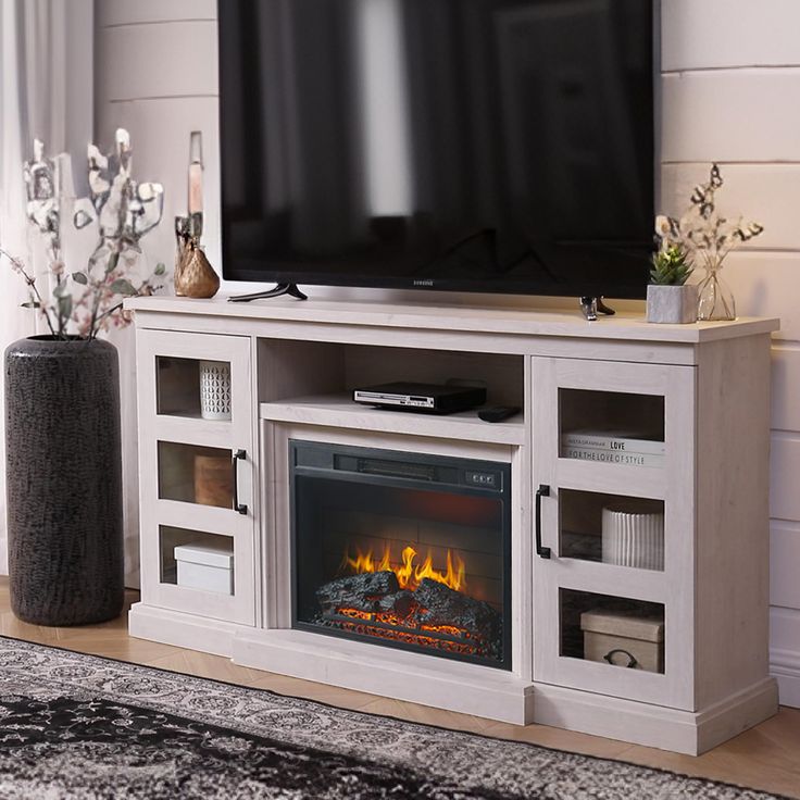 an entertainment center with a fireplace in the middle and a large television on it's stand