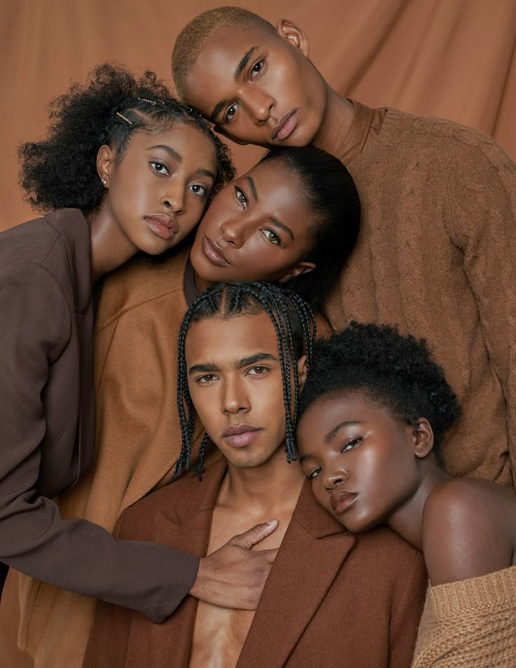 the cast of bello poses for a photo in front of a brown background with their arms around each other