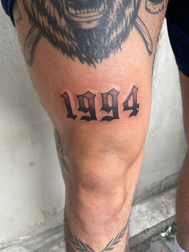 a man with a bear tattoo on his leg and the number four is in front of him