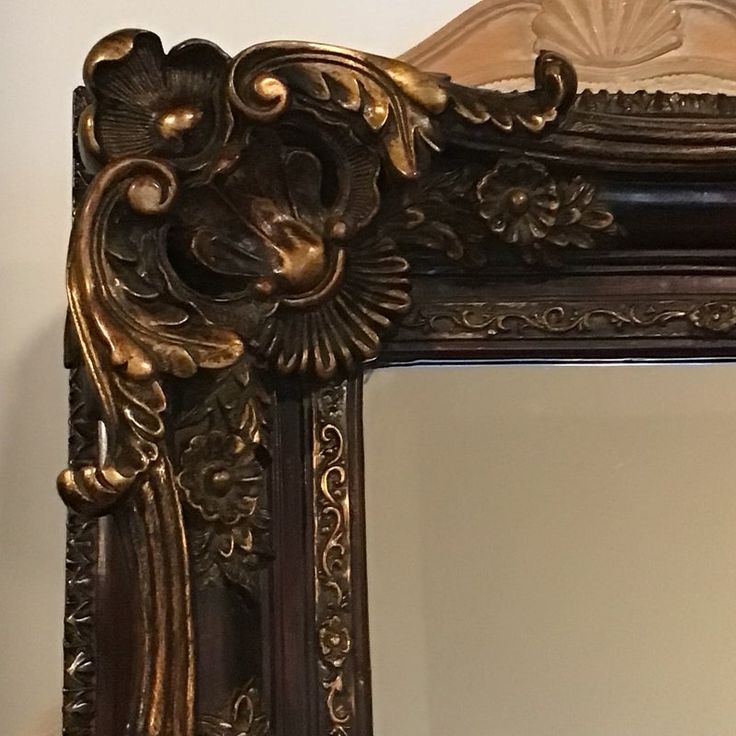 an ornate gold framed mirror on the wall