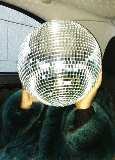 a person holding a disco ball up to their face with the words celebrate good time