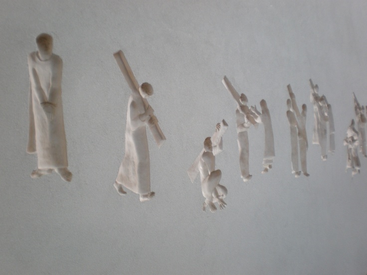 several pieces of paper are hanging on the wall next to each other, with one person holding a stick