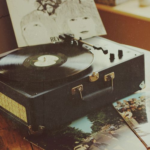 an old record player sitting on top of a table next to a book and album