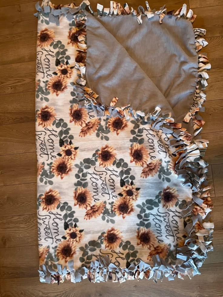 a blanket with sunflowers on it laying on the floor