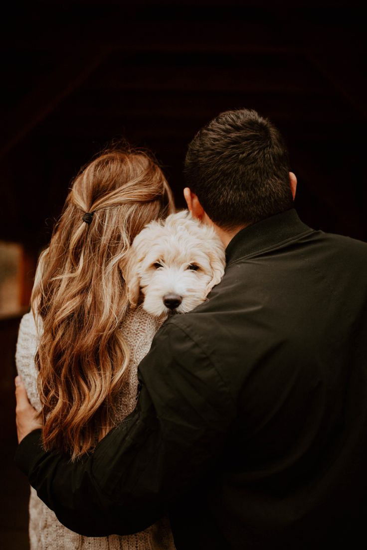 a man and woman holding a dog in their arms