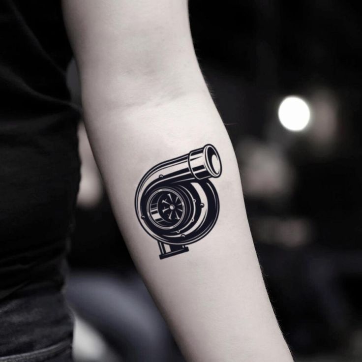 a black and white photo of a person's arm with a tattoo on it