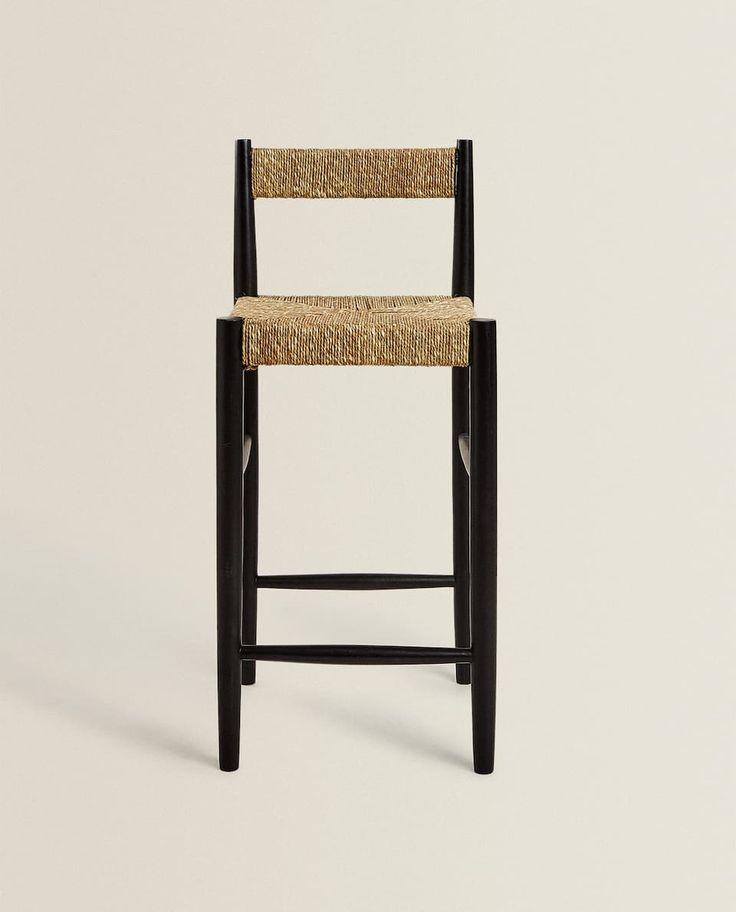 a chair with a seat made out of straw and black wood, against a white background