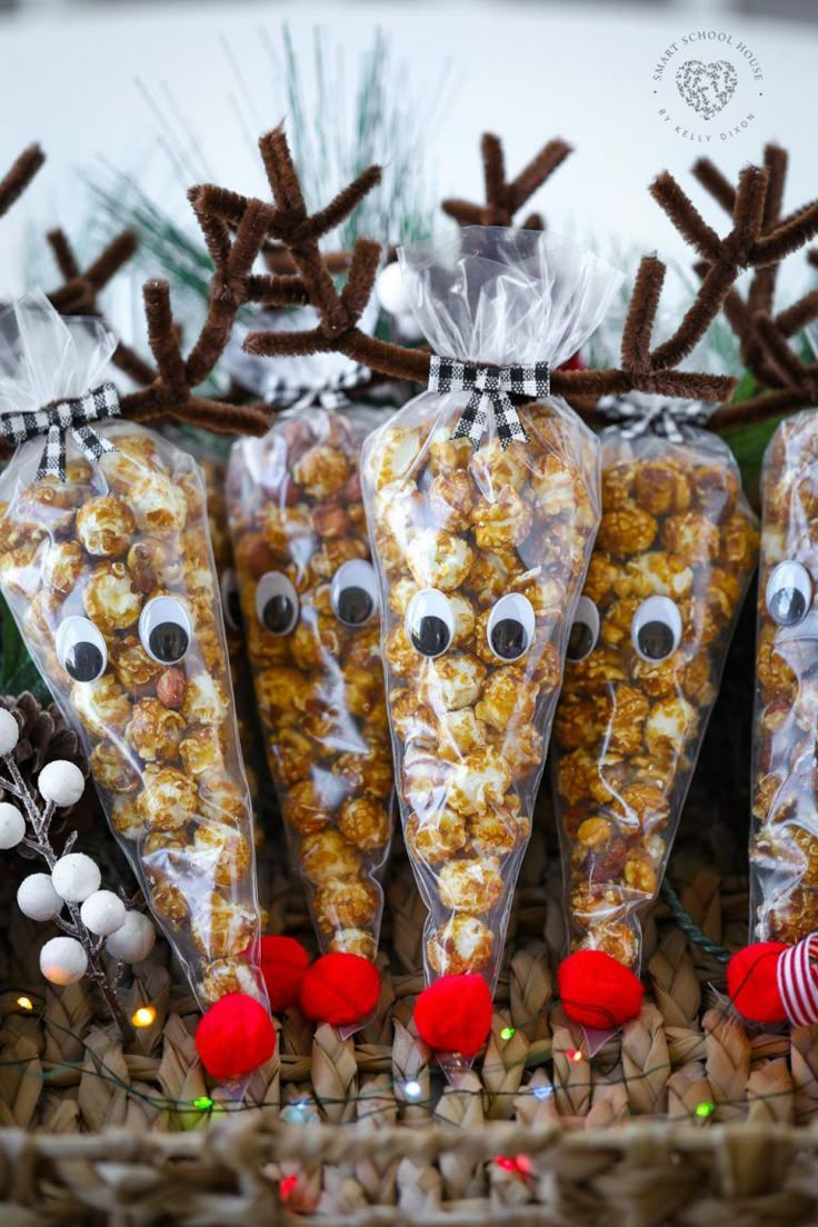 three bags of popcorn with reindeer noses on them and candy balls in the shape of antlers