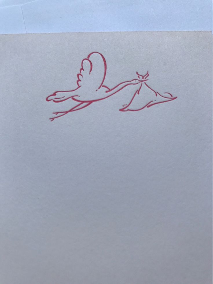 a drawing of a stork carrying a baby in it's mouth on top of a piece of paper