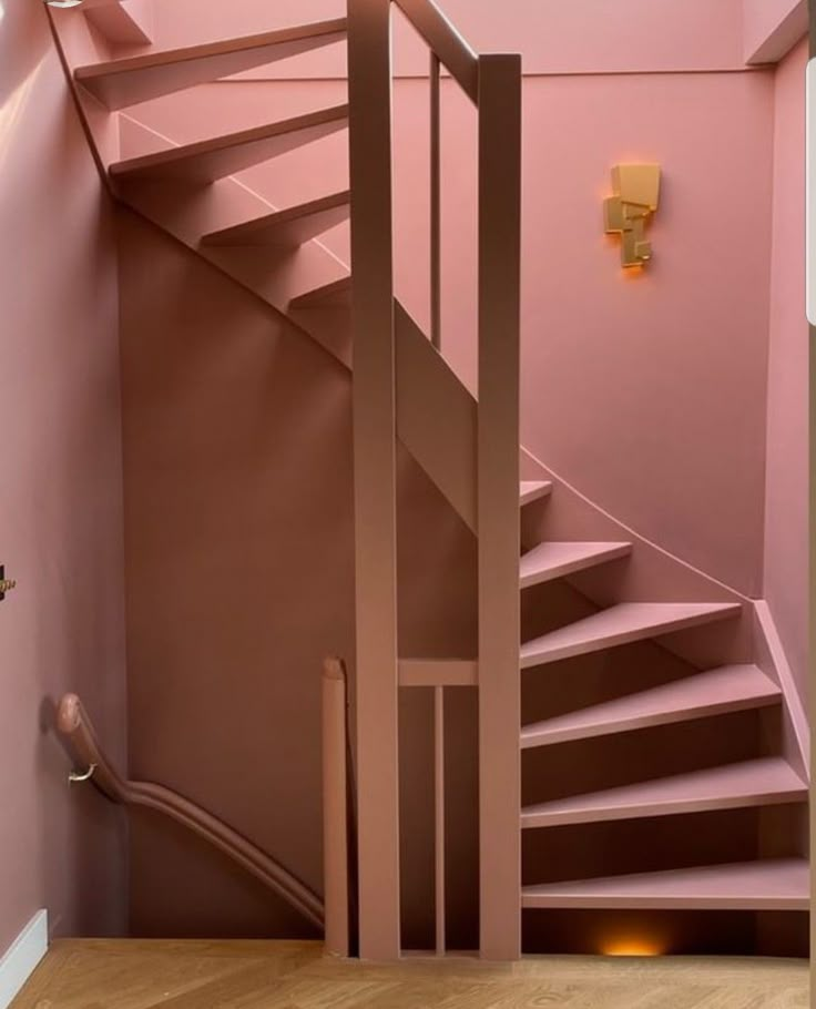 a pink staircase in a home with wooden floors