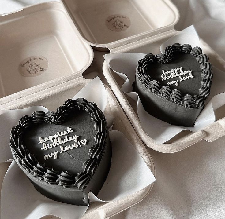 three heart shaped cakes sitting in trays on a table