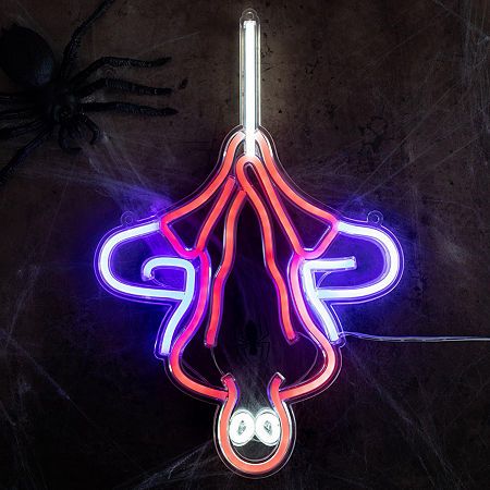 a neon sign hanging from the side of a wall next to a spider on it