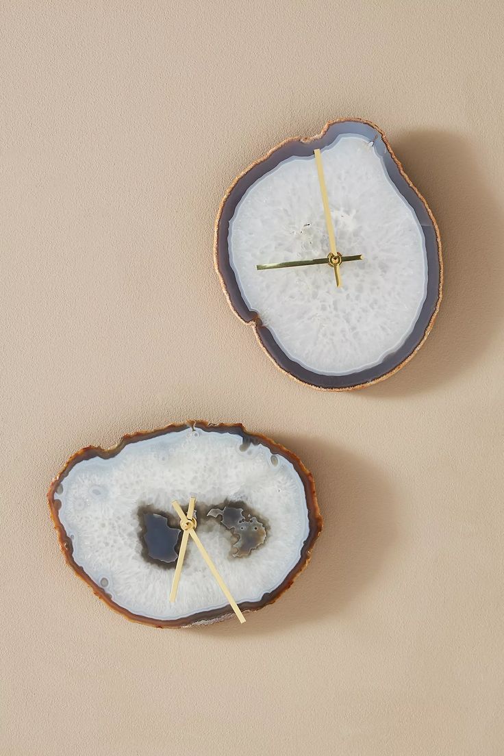 two pieces of wood with some sort of decoration on top of each other and a clock in the middle