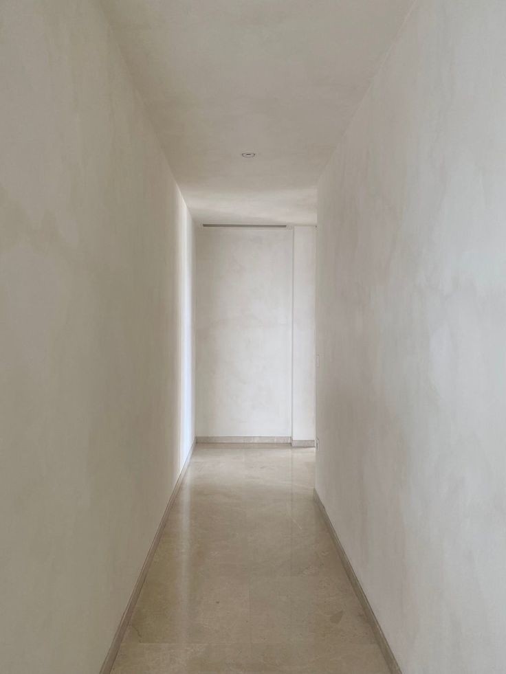 an empty hallway with white walls and floor