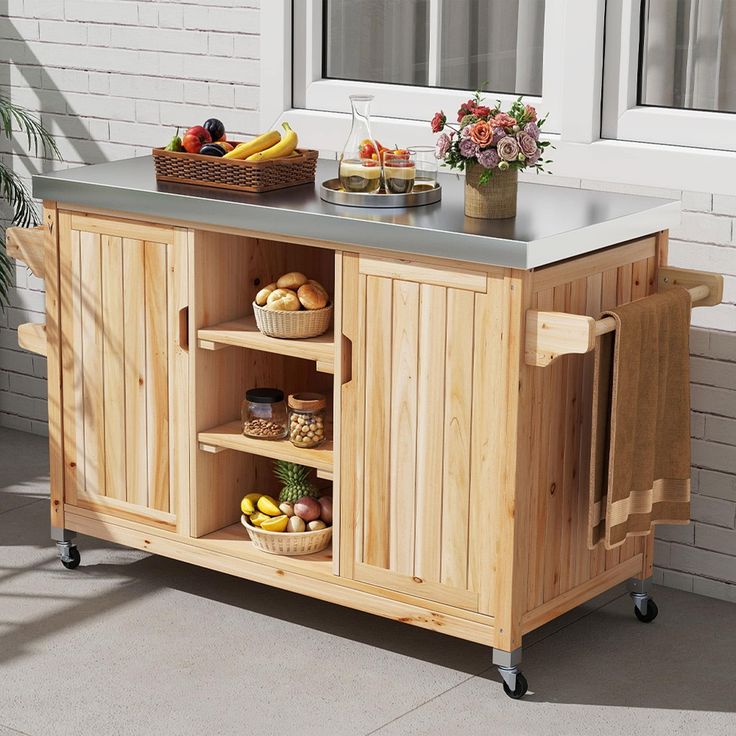 a kitchen island with food on it in front of a window and potted plants