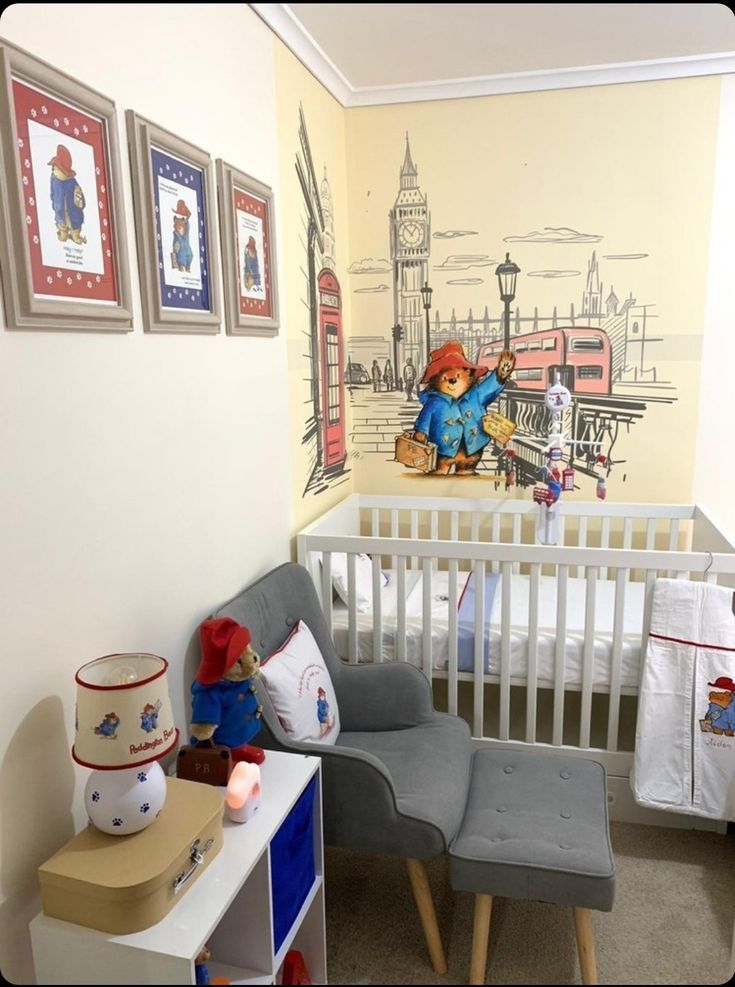 a baby's room with a crib, chair and pictures on the wall