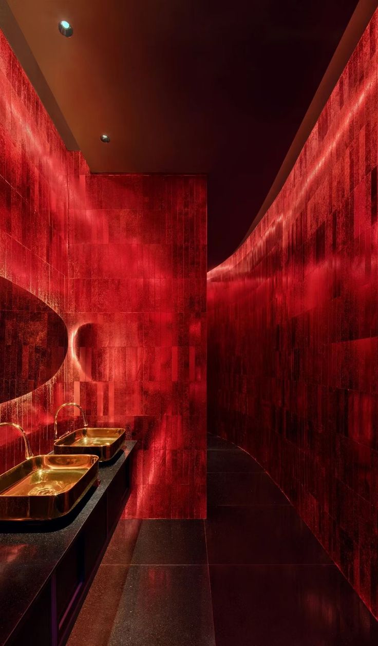 a bathroom with red walls and sinks in it