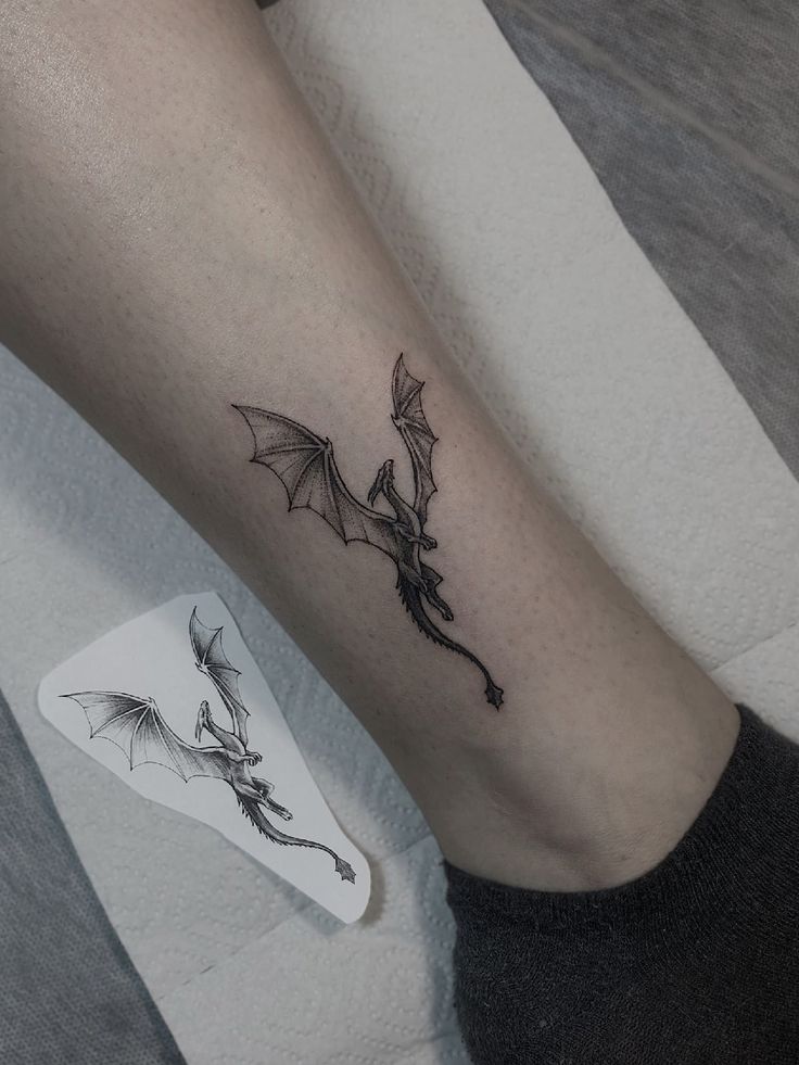 a tattoo on the leg of a woman with a dragon and flower in her left arm