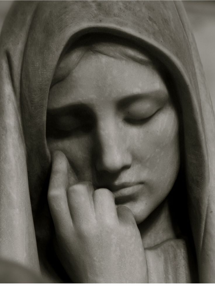 black and white photograph of a statue with her hands on her face