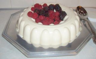 a white cake with berries and cream on top