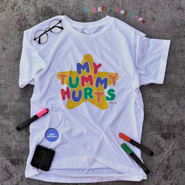 My tummy hurts tee is the perfect funny shirt to wear as your next meme shirt. Inspired by clowncore clothing and kidcore clothes - the playful colors and original hand written lettering will surely bring colors to your days. This funny meme shirt is a perfect addition to your kidcore tee collection or as your daily clown shirt. This clowncore shirt is also the perfect funny gift for her, gift for him or anyone you know who suffers from IBS, survived a diarrhea or for anyone you love who always get tummy aches as these oddly specific meme shirts are unisex. Available in XS, S, M, L, XL, 2XL, & 3XL ✨ 100% ⭐️ PREMIUM ⭐️ Airlume combed and ringspun cotton  ✨ Light fabric ✨ Retail Unisex fit ✨ Tear away label ✨ Runs true to size ✨ Original Lettering Font & Design by MilkDesigns ‼️ Print Size w Kidcore Shirt, Kidcore Clothes, Kidcore Clothing, Clown Shirt, My Tummy Hurts, Tummy Hurts, Tee Shirt Outfit, Meme Shirts, Funny Gifts For Her