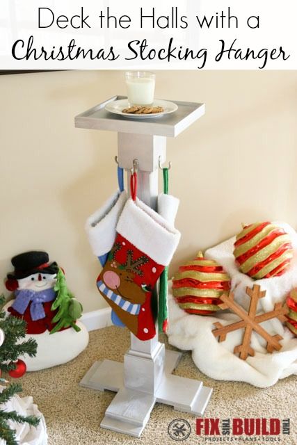 christmas stockings hanging on a stand with other ornaments and decorations in the corner next to it