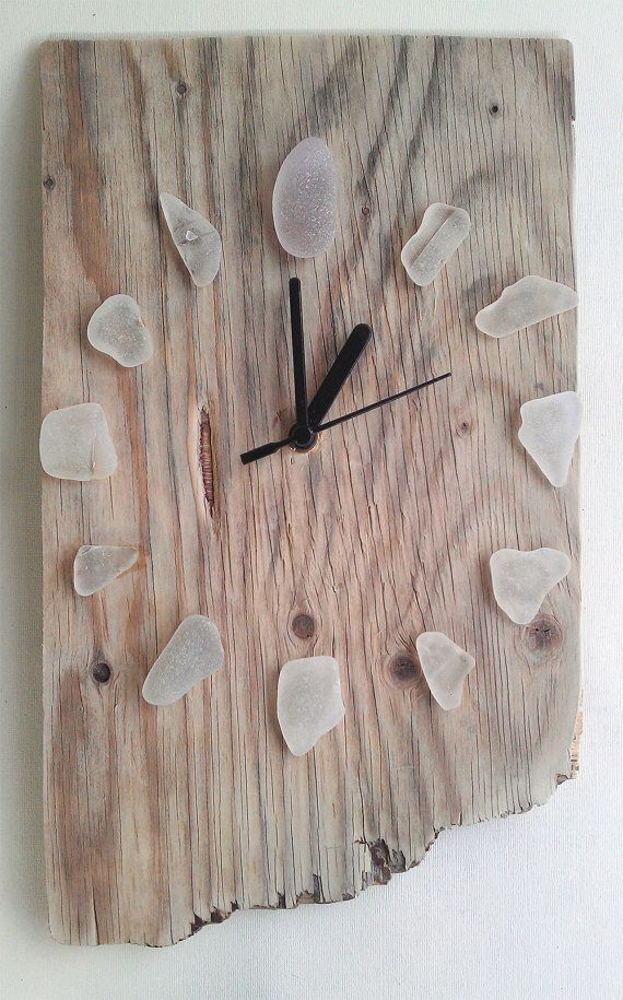 a clock made out of wood with white rocks on the face and numbers in black