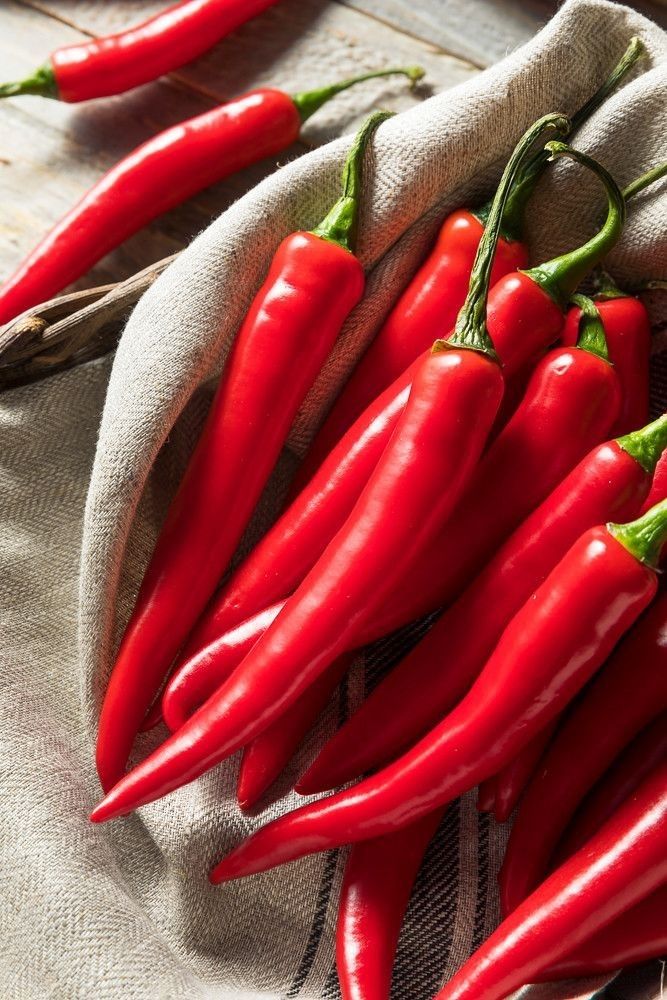 some red peppers are sitting on a cloth in front of a white bag with the words red finder peppers