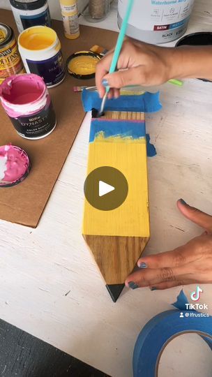 a person is painting on wood with paint