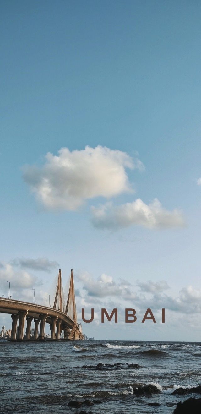 a large bridge over water with the word umba in it's center surrounded by clouds