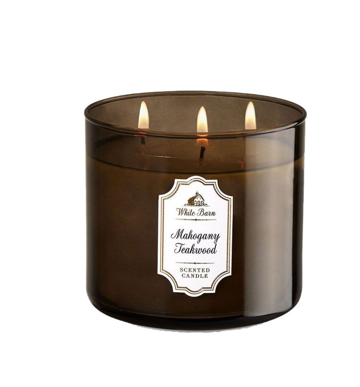 a brown candle with three lit candles in it's center and the words mahogany wood on