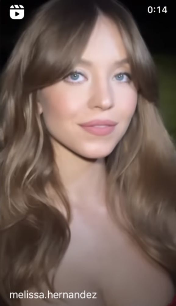 a woman with long blonde hair and blue eyes is looking at the camera while wearing a red dress