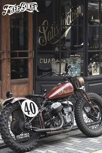 a red motorcycle parked in front of a store with the number forty written on it