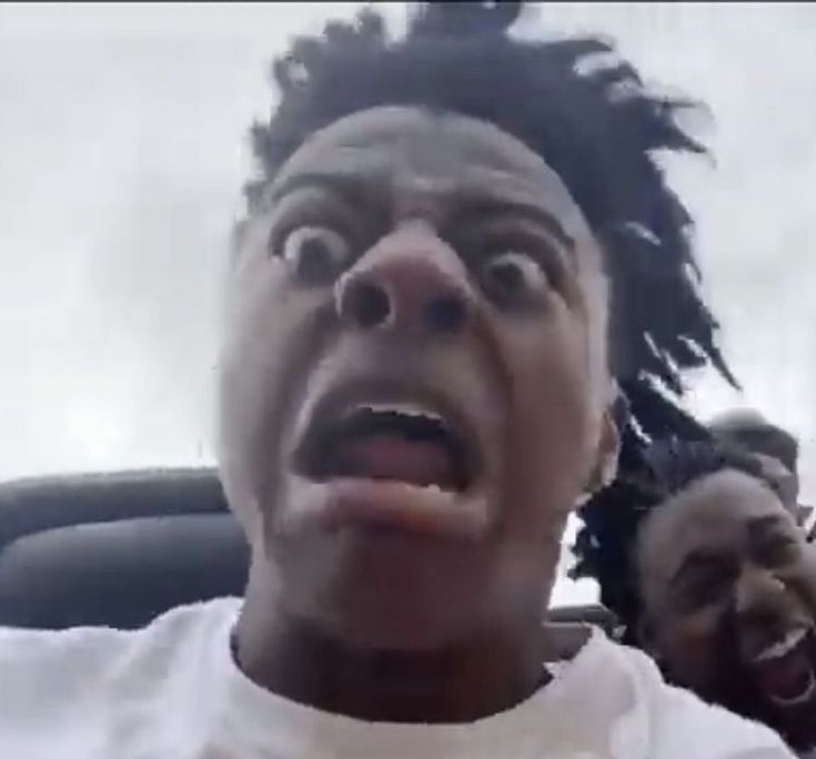 a man with dreadlocks is making an angry face in the back seat of a car