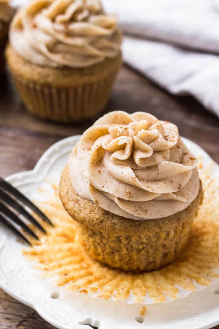 two cupcakes with frosting and sprinkles on a plate